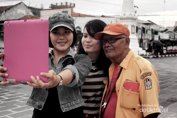 Seorang kakek penjaga parkir tidak sungkan untuk berpose ketika diajak selfie oleh dua turis yang sedang jalan-jalan di sekitar tugu Yogyakarta. Selfie memang tidak mengenal usia. Seorang kakek penjaga parkir tidak sungkan untuk berpose ketika diajak selfie oleh dua turis yang sedang jalan-jalan di sekitar tugu Yogyakarta. Selfie memang tidak mengenal usia.