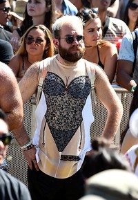 Kocak! Seorang penonton laki-laki mengenakan baju dengan gambar tubuh perempuan ber-lingerie. Frazer Harrison/Getty Images for Coachella/detikFoto.