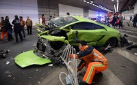     Petugas berusaha mengevakuasi supercar yang terlibat kecelakaan itu. Beberapa bagian dinding di terowongan itu terlihat rusak akibat kecelakaan.Pool/AFP/detikFoto.