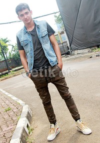 Ia memadukan celana army-nya dengan kaus hitam, rompi denim dan sepatu putih. Pool/Gus Mun/detikFoto.