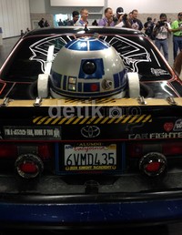 Droid R2-D2 bercokol di bagian belakang mobil, seperti yang dilakukannya di pesawat X-Wing Starfighter di film 'Star Wars'
