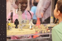 Penggemar cilik sedang memandang karakter Star Wars yang dibuat dari LEGO.