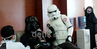 Stormtrooper memegang tangan Darth Vader yang sedang donor darah, sementara Darth Nihilius hanya mengintip dari kejauhan.
