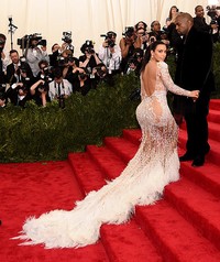 Kim Kardashian mengenakan gaun rancangan Roberto Cavalli menerawang dengan detail bulu yang menyapu lantai. Dimitrios Kambouris/Getty Images/detikFoto.