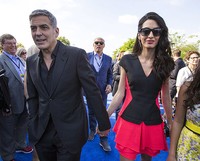 Romantis, George Clooney tak melepaskan genggaman tangannya dari sang istri. REUTERS/Mario Anzuoni/detikFoto.