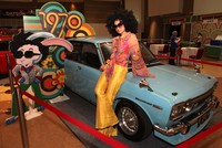 Seorang model perempuan berpose di samping mobil Datsun tahun 1970-an. Ist/Nissan.