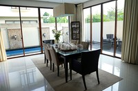 Ruang makan terlihat nyaman dan terkesan terbuka dengan jendela dan pintu kaca yang besar.