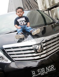 Falhan tampak asyik berpose di atas mobil Vellfire hitam. Pool/Gus Mun/detikFoto.
