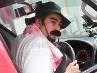 Kenakan topi berwarna hijau, kaus putih serta handuk pink di leher, Raffi menyamar jadi sopir angkot. Pool/Gus Mun/detikFoto.