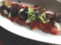 Salmon ini tak memerlukan proses memasak lagi, bisa langsung dimakan segar. Chef Chandra mengiris tipis salmon yang sudah disiapkan. Kemudian menata potongan beet root, daun selada dan keju ricotta.