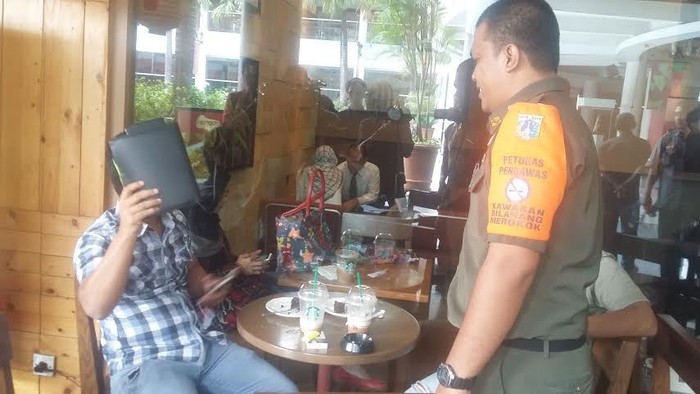 Kepergok Merokok di Mal Citos, Pria Ini Tutupi Muka dengan Buku Menu