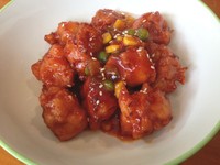 Dak Kang Jhon, ayam goreng tepung lembut diberi saus kental kemerahan. Terdapat jagung pipil, kacang polong, potongan bawang bombay, dan cabai dalam saus ayam. Saus ini memiliki rasa asam manis cukup kuat dengan sedikit jejak pedas.