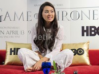 Mengenakan busana berwarna putih, ia pun tak ragu-ragu untuk duduk bersila di atas sofa sambil menjawab pertanyaan para wartawan.
