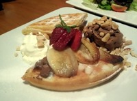 Dua buah waffle yang diolesi dengan selai nutella terasa manis dan enak. Dilengkapi dengan tambahan pisang panggang lembut dan es krim cokelat yang lembut dingin. Tak lupa juga ada taburan kacang mede yang gurih.