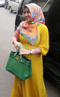 Di kesempatan itu, Shinta tampil dengan busana berwarna kuning terang dengan sentuhan pink, hijab bernuansa oranye dan tas hijau.