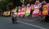 Warga melintas di depan karangan bunga ucapan selamat atas pernikahan Gibran dan Selvi di Kawasan Lokasi Resepsi Gedung Graha Saba, Jalan Letjen Soeprapto, Sumber, Solo, Jawa Tengah, Rabu (10/6/2015).