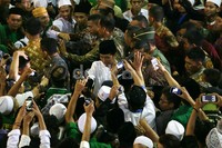 Para santri mengabadikan Jokowi menggunakan kamera maupun handphone.