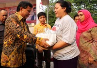 Ketua Fraksi Partai Hanura Nurdin Tampubolon menyerahkan sembako kepada warga di sekitar Stasiun Manggarai. Pool/Lamhot Aritonang/detikFoto.