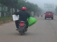 Pengendara motor hanya mengandalkan tangan kanannya saja untuk mengendalikan motor skutiknya. (Foto Reza Faisal).