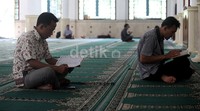 Sebagian warga menghabiskan waktu menunggu berbuka puasa dengan beristirahat di masjid Al-Bina, Senayan, Jakarta, Jumat (19/06/2015).     