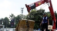 Alat berat memindahkan beton-beton pembatas jalan.