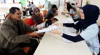 Petugas tengah menjelaskan mobil yang dijual pada calon konsumen. Penjualan mobil bekas diharapkan bisa naik menjelang lebaran ini.