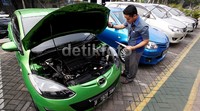 Mekanik mengecek kondisi mobil bekas yang akan dijual.