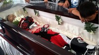 Jenazah pria yang akrab disapa Popo ‎juga dibalut pakaian dan perlengkapan rider, mulai dari jaket, sepatu, hingga sarung tangan.