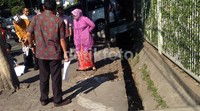 Risma yang berjarik motif warna cokelat kombinasi keunguan dengan dipadu atasan warna ungu itu sambil memegang Handy Talki (HT) itu mengecek pengerjaan saluran air di Jalan Mayjen Sungkono yang sempat berhenti terkait kontroversi kepemilikan lahan dan adanya pipa PDAM. M Fikser/detikFoto.