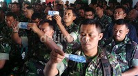 Babinsa menerawang uang pecahan Rp 50 ribu saat mengikuti sosialisasi uang palsu yang digelar BI.