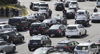 Para sopir taksi yang memprotes Uber melakukan blokir di akses jalan menuju bandar udara Paris. (gettyimages)