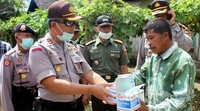 Seorang warga menerima beberapa bungkus masker. Ist/Humas Polres Bondowoso.