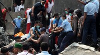 Petugas mengevakuasi jenazah korban jatuhnya pesawat Hercules C-130. AFP/Atar.