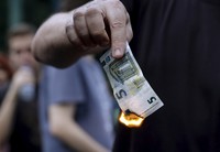 Seorang warga membawa uang Euro. REUTERS/Alkis Konstantinidis.