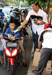 Anggota komunitas Suzuki Ertiga membagikan takjil kepada pengendara sepeda motor. Ist/Ertigamania.