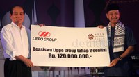 Presiden Lippo Group Theo L Sambuaga memberikan bantuan beasiswa kepada Ketua Umum Asia 87 Foundation Dwimawan Heru Santoso saat acara buka puasa bersama anak yatim di Balai Kartini, Jakarta, Sabtu (4/7/2015).