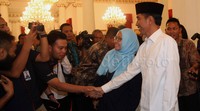 Jokowi menyalami wartawan.