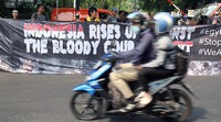 Pengendara melintas di depan spanduk yang dibawa pendemo. Pool/dok KMKD.