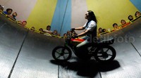 Yanti bersikap tenang dan konsentrasi saat memacu motornya.