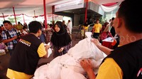 Petugas menyerahkan paket sembako murah.