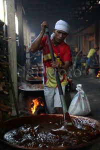 Pekerja tengah mengaduk adonan dodol Betawi di tempat pembuatan dodol di Pasar Minggu, Jakarta, Rabu (8/7/2015).