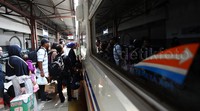 Para pemudik mengantre memasuki kereta api.