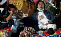 Calon penumpang tampak membawa barang-barang khas mudik seperti tas dan kardus besar.
