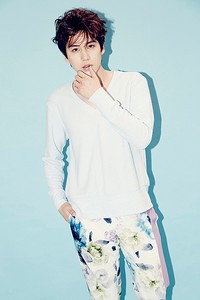 Kyuhyun mengenakan kaus lengan panjang putih dan celana bermotif floral. (SMTOWN)