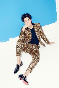 Berpose di dinding putih dengan sentuhan cat biru, Donghae tampil mengenakan kaus biru yang dipadu dengan setelan bermotif kulit leopard. (SMTOWN)