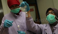 Dua petugas BPOM mengecek zat yang terkandung dalam makanan dalam sidak tersebut.     