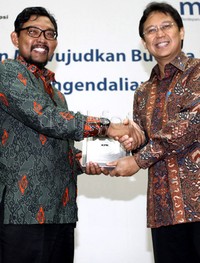 Perwakilan Bank Mandiri dan KPK bertukar cenderamata.