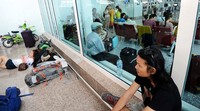 Calon penumpang bertahan dengan duduk dan tiduran di ruang tunggu bandara. Sonny Tumbelaka/AFP/detikFoto.