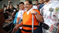 Ilham Arief berjalan menuju mobil tahanan yang menunggunya di depan gedung KPK.