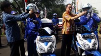 Presiden Direktur PT Astra International Tbk Prijono Sugiarto (kanan) memakaikan helm kepada mekanik Astra Holiday Campaign (AHC) 2015.